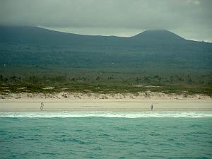 Volcanic features visible in the distance, beyond the beach at Tortuga Bay in the Galapagos Islands.